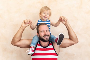 Adam ve çocuk evde. Baba ve oğul birlikte eğleniyor. Aile tatil kavramı. Mutlu babalar günü