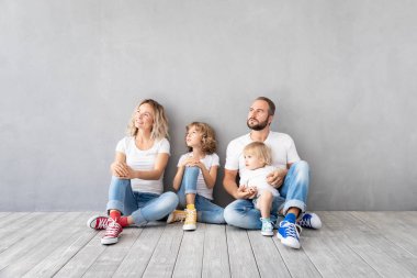 Yeni evinde oynayan iki çocukları ile mutlu bir aile. Baba, anne ve çocuk birlikte eğleniyor. Hareketli ev gün ve gayrimenkul konsept
