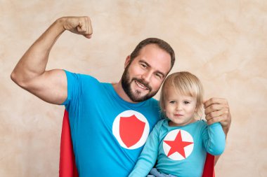 Adam ve çocuk süper kahraman evde. Süper kahraman baba ve oğul birlikte eğleniyor. Aile tatil kavramı. Mutlu babalar günü