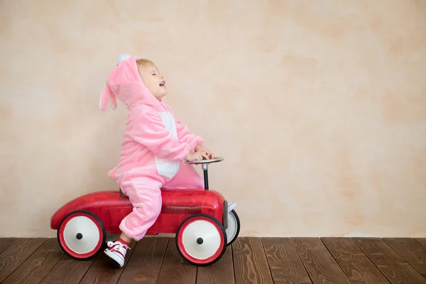 Chico Gracioso Vistiendo Conejo Pascua Niño Montar Coche Juguete Casa — Foto de Stock