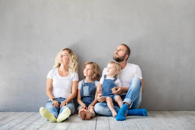 Yeni evine oynayan iki çocukları ile mutlu bir aile. Baba, anne ve çocuk birlikte eğleniyor. Hareketli ev gün ve gayrimenkul konsept