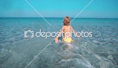 Denizde oynayan mutlu çocuk. Çocuk sahilde eğleniyor. Yaz tatili ve aktif yaşam tarzı konsepti