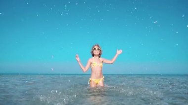 Denizde oynayan mutlu çocuk. Çocuk sahilde eğleniyor. Yaz tatili ve aktif yaşam tarzı konsepti