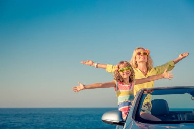 Mutlu aile araba ile seyahat. İnsanlar mavi cabriolet eğleniyor. Yaz tatil kavramı