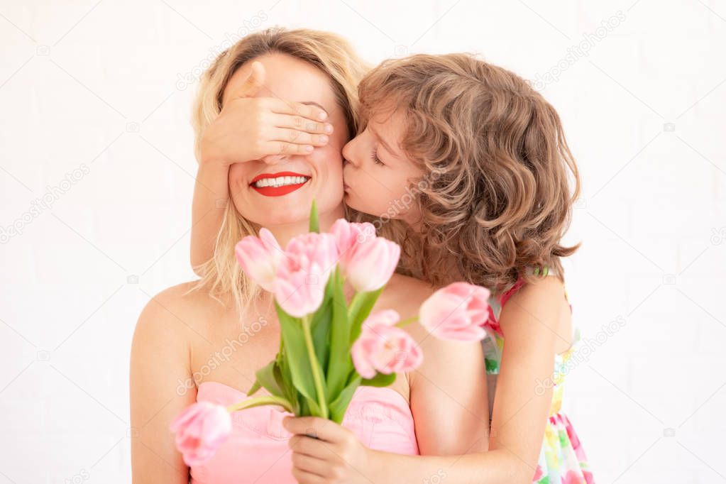 Child giving woman bouquet of tulips. Mother and daughter having fun together. Spring family holiday concept. Mother's day
