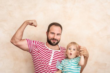 Adam ve çocuk evde. Baba ve oğul birlikte eğleniyor. Aile tatil kavramı. Mutlu babalar günü
