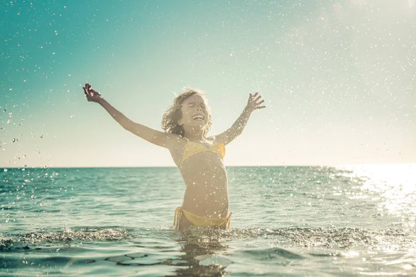 Denizde oynayan mutlu çocuk. Çocuk yaz tatile eğleniyor. Sağlıklı aktif yaşam tarzı kavramı