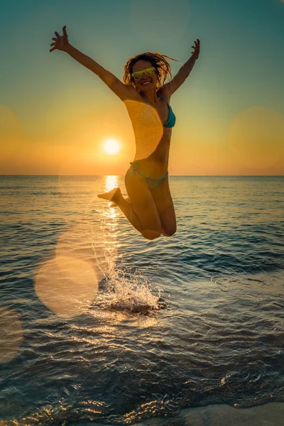 Ευτυχισμένη γυναίκα πηδώντας στη θάλασσα — Φωτογραφία Αρχείου