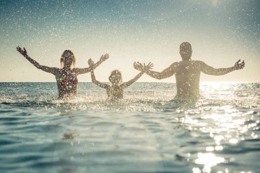 Denizde mutlu bir aile. Çocuk, anne ve baba yaz tatile eğleniyor. Sağlıklı aktif yaşam tarzı kavramı