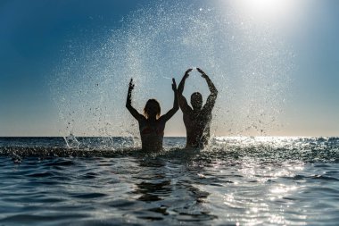 Denizde mutlu bir çift. Erkek ve kadın yaz tatile eğleniyor. Sağlıklı aktif yaşam tarzı kavramı