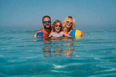 Mutlu bir aile deniz plaj topu ile oynamak. Sağlıklı aktif yaşam tarzı kavramı