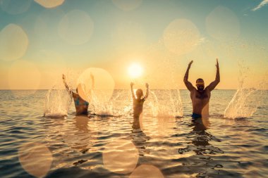 Denizde mutlu bir aile. Çocuk, anne ve baba yaz tatile eğleniyor. Sağlıklı aktif yaşam tarzı kavramı