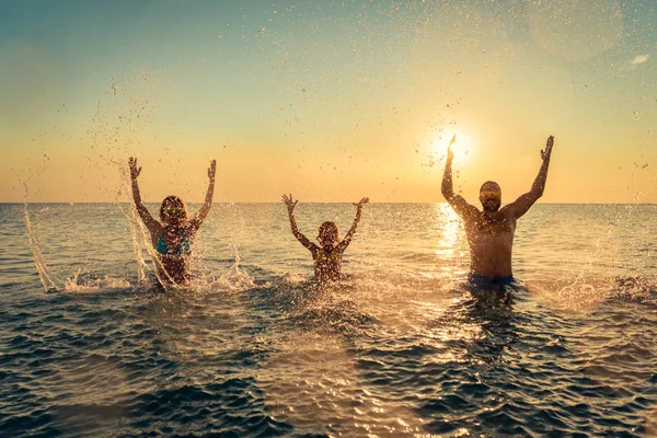 Счастливая семья играет в море — стоковое фото