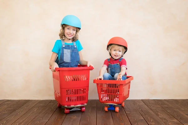 Щасливі діти за кермом іграшкового автомобіля вдома — стокове фото