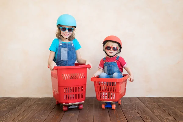 Niños felices conduciendo coche de juguete en casa — Foto de Stock