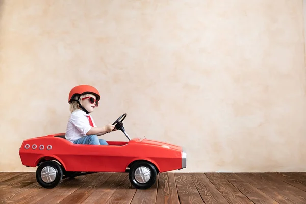 Αστείο παιδί οδηγώντας αυτοκίνητο παιχνίδι στο σπίτι — Φωτογραφία Αρχείου