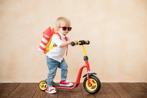 Glückliches Kind spielt zu Hause mit Spielzeugrakete — Stockfoto