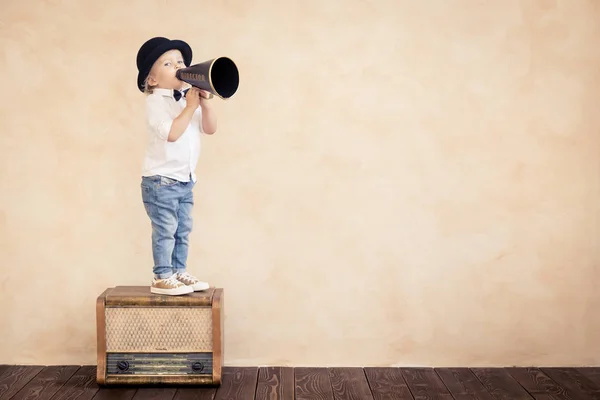 Criança engraçada brincando com megafone retro preto — Fotografia de Stock