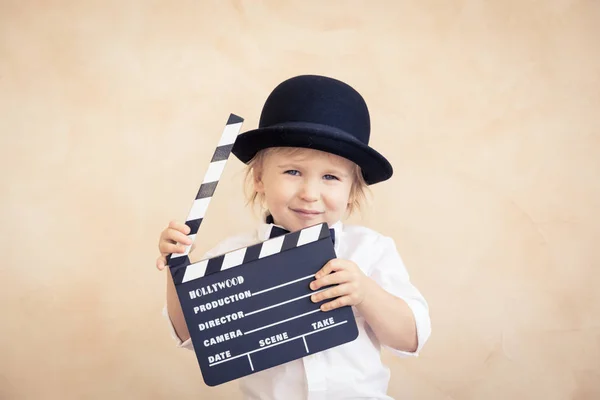 Niño con tablero de aplausos jugando en casa . — Foto de Stock