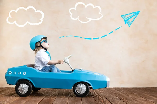 Engraçado garoto condução brinquedo carro em casa — Fotografia de Stock