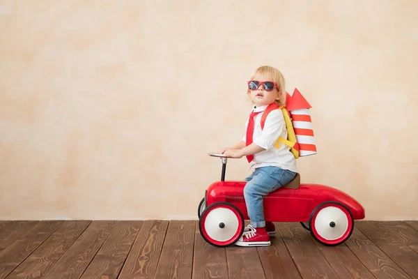 Criança feliz brincando com foguete de brinquedo em casa — Fotografia de Stock