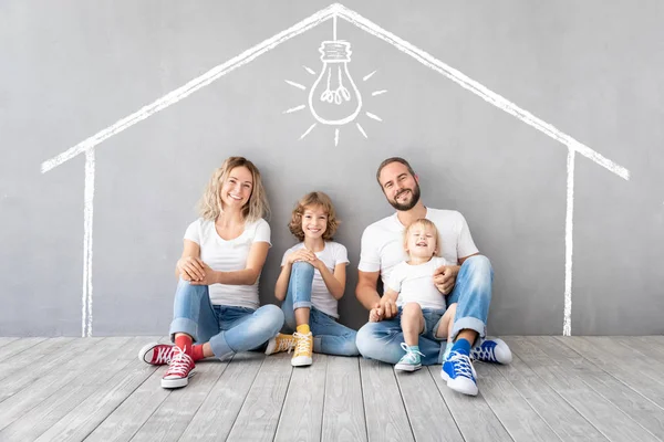 Família feliz com dois filhos brincando em uma nova casa — Fotografia de Stock