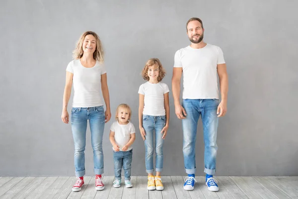 Famille heureuse debout sur fond gris — Photo
