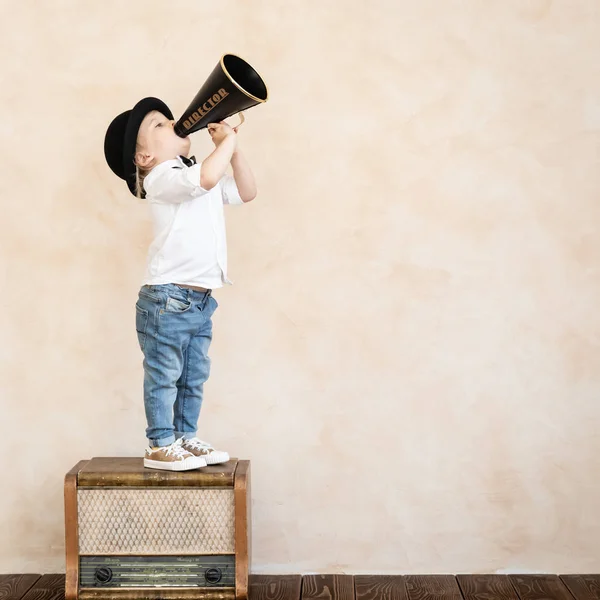 Criança engraçada brincando com megafone retro preto — Fotografia de Stock