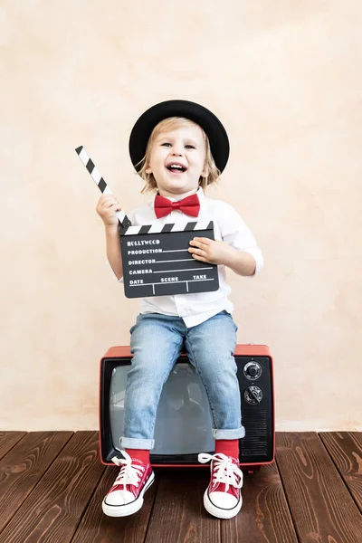 Niño con tablero de aplausos jugando en casa . — Foto de Stock