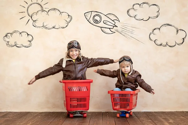 Bambini felici che guidano auto giocattolo a casa — Foto Stock