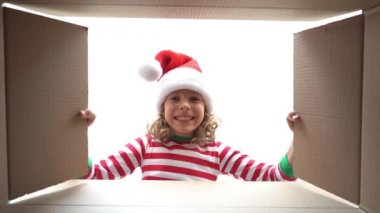 Mutlu çocuk kutuya bakıyor. Komik sürpriz kız Noel hediye kutusu açmak. Xmas tatil konsepti. Düşük açı görünümü. Yavaş çekim