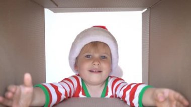 Mutlu çocuk kutuya bakıyor. Komik sürpriz çocuk Noel hediye kutusu açmak. Xmas tatil konsepti. Düşük açı görünümü. Yavaş çekim