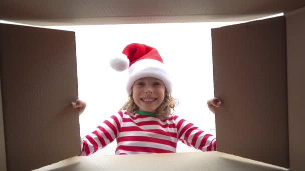 箱の中を見て幸せな子供 面白い驚いた女の子はクリスマスギフトボックスを解凍します エクスマスホリデーコンセプト 低角ビュー スローモーション — ストック動画