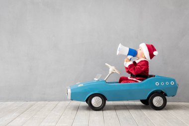 Mutlu çocuk noel baba kostümü evde oynarken giyinmiş
