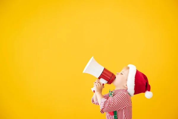 Criança feliz vestindo traje de Papai Noel falando por megafone — Fotografia de Stock