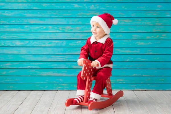 Gelukkig kind gekleed Santa Claus hoed tegen blauwe achtergrond — Stockfoto