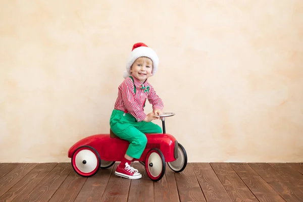 Criança feliz vestindo traje de Papai Noel jogando em casa — Fotografia de Stock