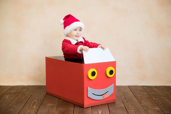 Criança feliz vestindo traje de Papai Noel jogando em casa — Fotografia de Stock