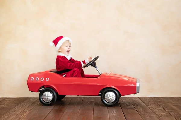 Счастливый ребенок в костюме Санта-Клауса играет дома — стоковое фото