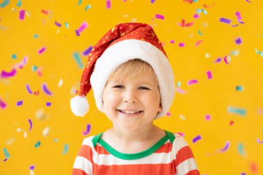 Komik çocuk sarı arka plan karşı Noel Baba şapka giymiş