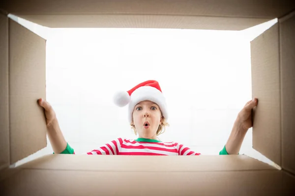 Überraschtes Kind packt Weihnachtsgeschenkschachtel aus — Stockfoto