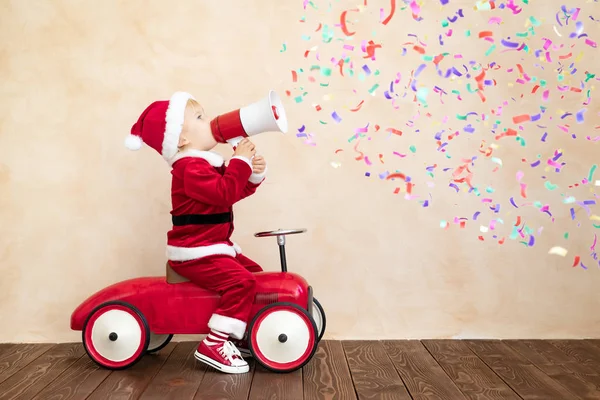 Счастливый ребенок одет костюм Санта-Клауса играть дома — стоковое фото