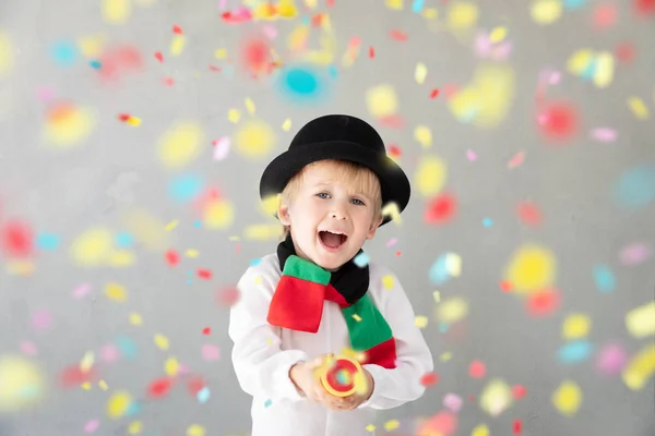 Happy child wearing snowman holding party popper — Stock Photo, Image