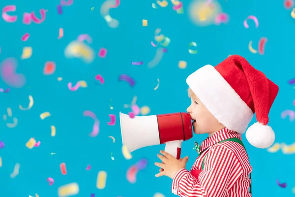 Criança feliz vestindo traje de Papai Noel falando por megafone — Fotografia de Stock