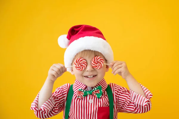 Glückliches Kind mit Lutscher in der Hand vor gelbem Hintergrund — Stockfoto