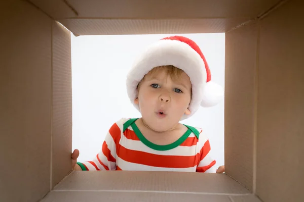 Verrast kind uitpakken de doos van de gift van Kerstmis — Stockfoto