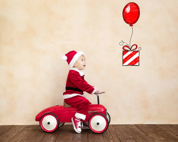 Happy Child klädd i jultomten kostym spela hemma — Stockfoto