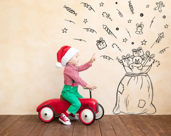 Criança feliz vestido traje de Papai Noel jogando em casa — Fotografia de Stock