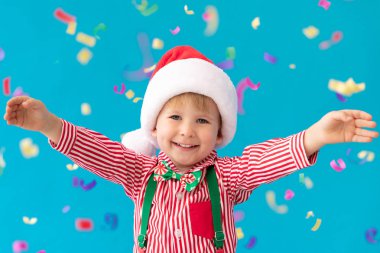 Mutlu çocuk mavi arka plan karşı Noel Baba şapka giymiş