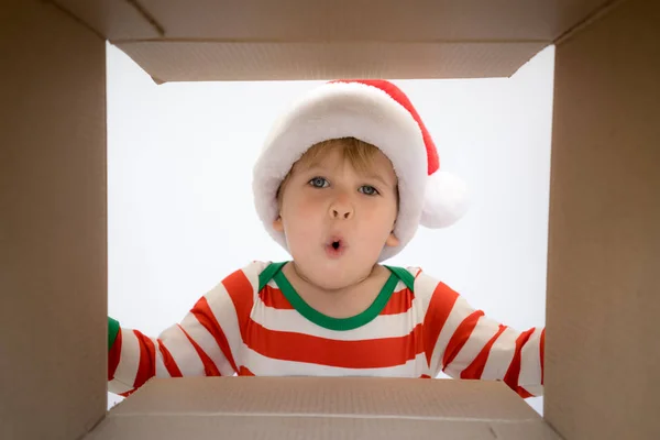 Verrast kind uitpakken de doos van de gift van Kerstmis — Stockfoto